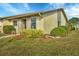 Side view of a light beige house with gray accents, landscaped lawn and bushes at 2709 60Th Avenue N Plz # D, Bradenton, FL 34207