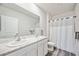 Clean bathroom with double sinks, a shower, and white cabinets at 3408 Hilltop Cir, Bradenton, FL 34211