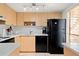 Modern kitchen with light wood cabinets, white backsplash and black appliances at 3421 Clark Rd # 122, Sarasota, FL 34231