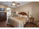 Primary bedroom with king-size bed, wood furniture, and access to bathroom at 3439 101St E Ave, Parrish, FL 34219