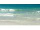 Picturesque beach scene featuring gentle waves and clear, light-blue water meeting a sandy shore at 3710 Gulf Of Mexico Dr # D19, Longboat Key, FL 34228