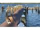 Waterfront dock with wooden posts, featuring easy water access and sturdy construction at 3710 Gulf Of Mexico Dr # D19, Longboat Key, FL 34228