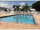 Outdoor pool with brick deck, metal handrails, and white fencing surrounded by palm trees and lawn chairs at 3710 Gulf Of Mexico Dr # D19, Longboat Key, FL 34228