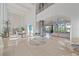 Open entryway with high ceilings, glass elevator, and modern furniture at 4136 Roberts Point Cir, Sarasota, FL 34242
