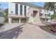 Grand two-story home with a three-car garage and lush landscaping at 4136 Roberts Point Cir, Sarasota, FL 34242