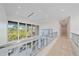 Bright hallway with glass railings and views to backyard at 4136 Roberts Point Cir, Sarasota, FL 34242