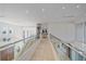 Elegant hallway with glass railings and home elevator at 4136 Roberts Point Cir, Sarasota, FL 34242