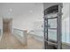 Modern home hallway with glass railings and elevator at 4136 Roberts Point Cir, Sarasota, FL 34242