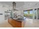 Modern kitchen island with breakfast bar, stainless steel appliances, and backyard view at 4136 Roberts Point Cir, Sarasota, FL 34242