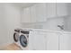 Laundry room with white cabinets and washer and dryer at 4136 Roberts Point Cir, Sarasota, FL 34242