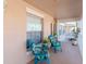 Small balcony with teal chairs and potted plants at 4207 Caddie E Dr # 202, Bradenton, FL 34203
