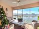 Enclosed balcony with lake view, wicker furniture and ceiling fan at 4207 Caddie E Dr # 202, Bradenton, FL 34203