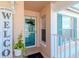 Front entrance with teal door and welcome sign at 4207 Caddie E Dr # 202, Bradenton, FL 34203