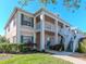 Two-story condo building with teal shutters, white railings, and landscaped grounds at 4207 Caddie E Dr # 202, Bradenton, FL 34203