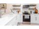 Modern white kitchen with stainless steel appliances and floating shelves at 4207 Caddie E Dr # 202, Bradenton, FL 34203