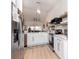 Modern white kitchen with stainless steel appliances and hardwood floors at 4207 Caddie E Dr # 202, Bradenton, FL 34203