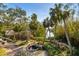 Landscaped backyard with lush tropical foliage and waterway views at 5112 Jungle Plum Rd, Sarasota, FL 34242