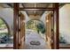 Open double doors reveal a courtyard with lush landscaping and a pathway at 5112 Jungle Plum Rd, Sarasota, FL 34242