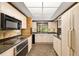 Retro kitchen with light wood cabinets, granite countertops, and tile floors at 5112 Jungle Plum Rd, Sarasota, FL 34242