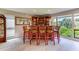 Traditional home bar with wood cabinetry, green barstools, and a view of the lake at 5369 Lake Arrowhead Trl # 17A, Sarasota, FL 34231
