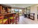 Home bar with wood cabinetry, green barstools, and a work area at 5369 Lake Arrowhead Trl # 17A, Sarasota, FL 34231