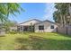 Large backyard with screened patio, fire pit, and fenced-in area at 5384 Sarapointe Ct, Sarasota, FL 34232
