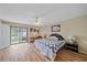 Main bedroom with hardwood floors, a comfortable bed, and access to a patio at 5384 Sarapointe Ct, Sarasota, FL 34232