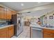 Kitchen boasts stainless steel appliances and wood cabinets, open to the living area at 5384 Sarapointe Ct, Sarasota, FL 34232
