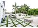 Landscaped backyard with a patio, artificial turf, and palm trees at 5906 Larchwood Ave, Sarasota, FL 34231