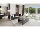 Open living room with gray sofa and coffee table, offering views of the backyard through sliding glass doors at 5906 Larchwood Ave, Sarasota, FL 34231