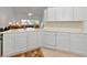 White kitchen with corner sink, dishwasher, and views into living room at 7107 Cedar Hollow Cir, Bradenton, FL 34203