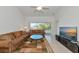 Spacious living room with a brown sofa, large TV, and sliding doors to balcony at 7107 Cedar Hollow Cir, Bradenton, FL 34203