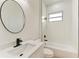 Bathroom with vanity, round mirror, and tub shower combo at 75 Mark Twain Ln, Rotonda West, FL 33947