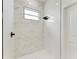 Walk-in shower with marble tile and herringbone floor at 75 Mark Twain Ln, Rotonda West, FL 33947