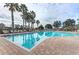 Relaxing community pool with lounge chairs and palm trees at 7923 111Th E Ter, Parrish, FL 34219