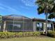 Tan house exterior with a screened patio overlooking a lake at 8199 Varenna Dr, Sarasota, FL 34231