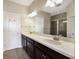 Double vanity bathroom with dark wood cabinets and a large mirror at 8199 Varenna Dr, Sarasota, FL 34231
