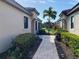 Brick walkway leading to the back of the property with lush landscaping at 8199 Varenna Dr, Sarasota, FL 34231