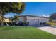 Tan two-car garage home with lush landscaping and a brick paver driveway at 8224 Varenna Dr, Sarasota, FL 34231