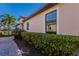 Landscaped walkway beside a tan home with large windows at 8224 Varenna Dr, Sarasota, FL 34231