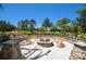 Outdoor fire pit area with stone seating and lush landscaping at 8224 Varenna Dr, Sarasota, FL 34231