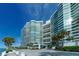 Modern waterfront building with palm trees and a paved courtyard at 888 Blvd Of The Arts # 1408, Sarasota, FL 34236