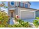 Two-story house with neutral siding, two-car garage, and landscaped yard at 10611 Ladybug Cv, Parrish, FL 34219