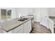 Modern kitchen with white cabinets, granite countertops, and island at 10611 Ladybug Cv, Parrish, FL 34219