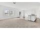 Open living room with carpeted floor, vinyl plank flooring in kitchen area, and access to backyard at 10611 Ladybug Cv, Parrish, FL 34219
