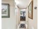 Hallway with framed artwork and carpet runner leading to bedroom at 1100 27Th W Ave, Palmetto, FL 34221