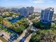 Aerial view of community entrance, lush landscaping, tennis courts, and ocean views at 1211 Gulf Of Mexico Dr # 403, Longboat Key, FL 34228