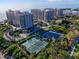 Aerial view of coastal community with tennis courts, ocean views, and multiple high-rise buildings at 1211 Gulf Of Mexico Dr # 403, Longboat Key, FL 34228