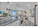 Modern kitchen with white cabinets, granite countertops, and stainless steel appliances at 1211 Gulf Of Mexico Dr # 403, Longboat Key, FL 34228