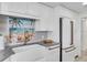 White kitchen with farmhouse sink and beach-themed backsplash at 1211 Gulf Of Mexico Dr # 403, Longboat Key, FL 34228